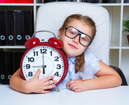 cute little girl wearing glasses with   a clockの写真素材