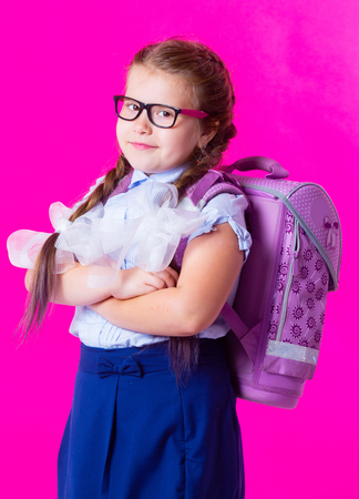 happy  little schoolgirl against pink backgroundの写真素材