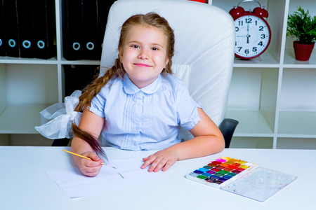 cute little girl painting with watercolor at homeの写真素材