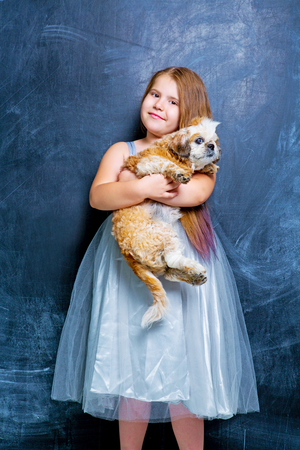 happy little girl with her dog against chalkboardの写真素材