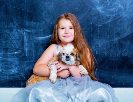 happy little girl with her dog against chalkboardの写真素材
