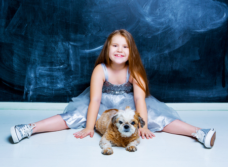 happy little girl with her dog against chalkboardの写真素材