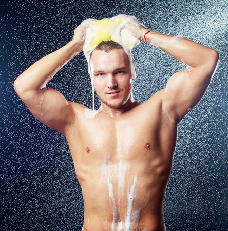 a handsome muscular attractive young man taking showerの写真素材