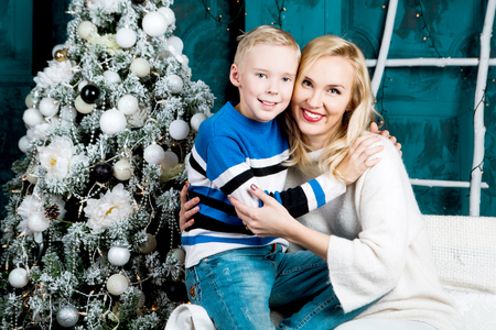 happy young mother and her son at home with a Christmas tree and presentsの写真素材