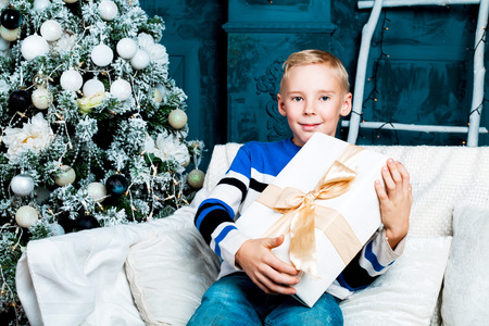 happy  boy at home with a Christmas tree and presentsの写真素材