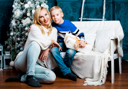 happy young mother and her son at home with a Christmas tree and presentsの写真素材