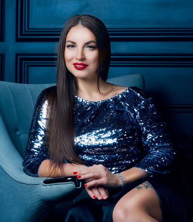 beautiful young brunette woman wearing a sparkling dressの写真素材