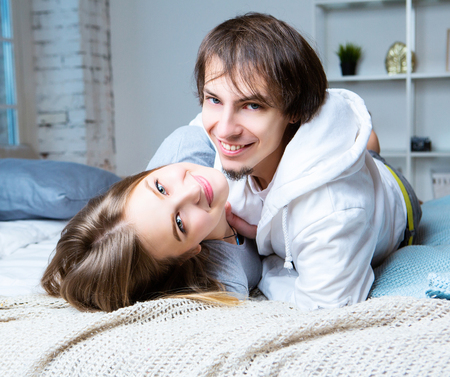 happy beautiful young couple at home in the bedroomの写真素材