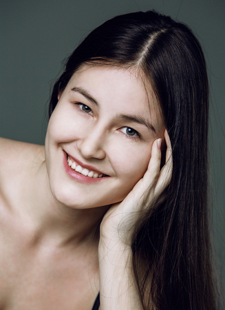 beautiful young asian woman without makeup against studio backgroundの写真素材