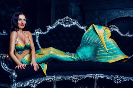 beautiful brunette model dressed as a mermaid , on the sofaの写真素材
