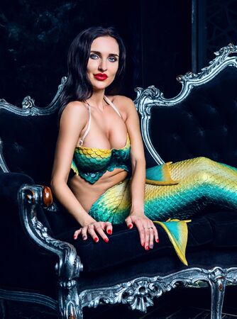 beautiful brunette model dressed as a mermaid , on the sofaの写真素材