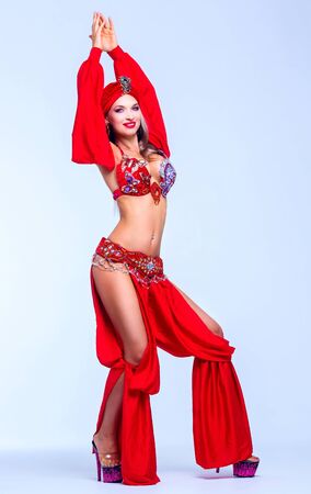beautiful sexy woman wearing a stage costume of a belly-dancer, in the studioの写真素材