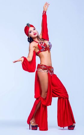 beautiful sexy woman wearing a stage costume of a belly-dancer, in the studioの写真素材