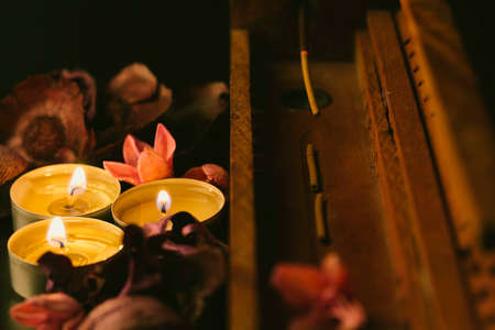 incense stick aroma with smoke in a wooden handmade holder with dried petals and candles isolated on...