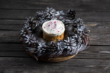 Easter cake with colored eggs on a dark wooden background in the center of the table