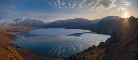 Panorama of a mountain lake with floating ice and icebergs at sunset. View from top of the reservoir Bartogay Kazakhstanの写真素材