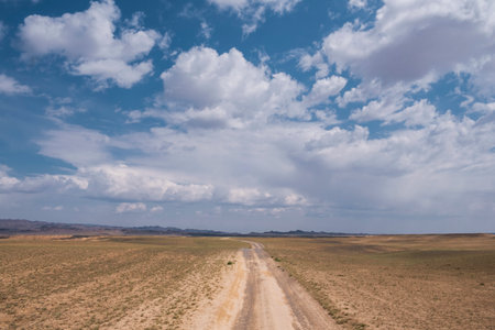 A country road in the summer under a clear blue sky - filmed in the stepspes of Kazakhstan. view of the old roadの写真素材