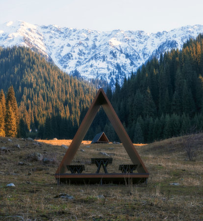 shelters in the autumn forest in the mountains against the backdrop of the Kumbel peak, covered with snowの写真素材