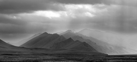 black and white landscape of twilight mountains in the haze of rainの写真素材