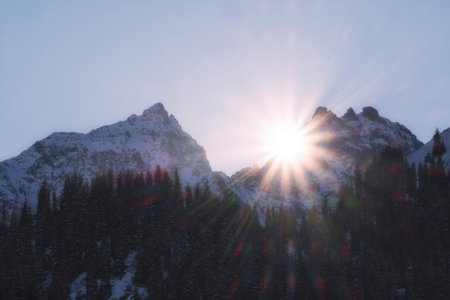 Sunset in the harsh and rocky winter mountains when the sun rays hide behind the rocks. Issyk Gorge...