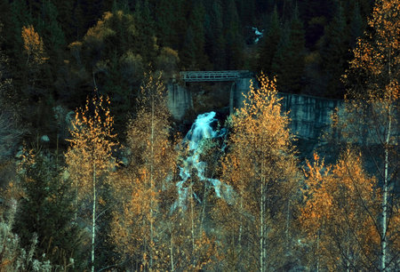 Bridge over forest waterfall in autumn mountains. Big Almaty gorge Kazakhstan.