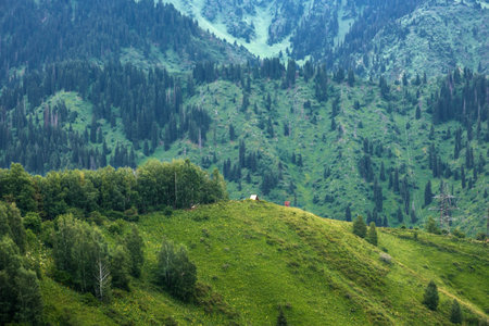 A small shelter or gazebo in the big mountains where you can take shelter from bad weather. Mountain summer landscape of the Zailiyskiy Alatau ridges in Almaty Kazakhstan.の写真素材