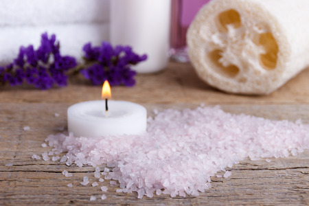 Spa. Lilac bath salt, sponge,lotion and towels on wooden background. Selective focusの写真素材