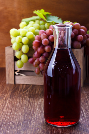 Homemade grape juice and fruits on wooden tableの写真素材