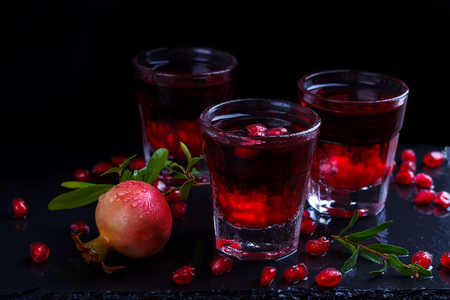 Delicious pomegranate cocktail on black stone backgroundの写真素材