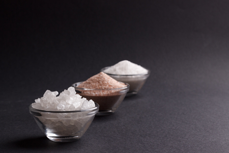 Three types of salt on dark background, selective focusの写真素材
