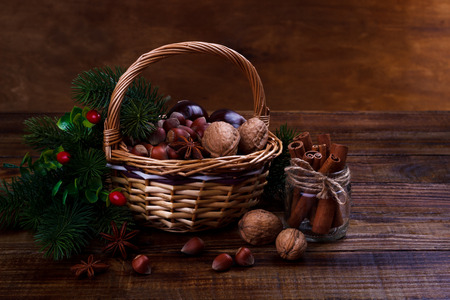 Assorted nuts and spices in a basket. Walnut,almond, peanut, hazelnut, cinnamon sticks,chestnuts and star anise. Autumn harvestの写真素材