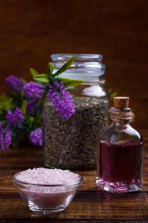 Spa setting and health care items, lavender handmade soap, body oil, bath salt and towel  on wooden boardの写真素材