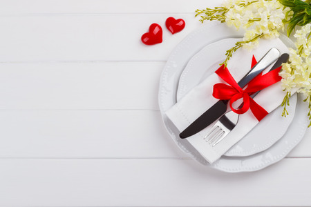 Romantic table setting on white wooden table. Valentine's day card templateの写真素材