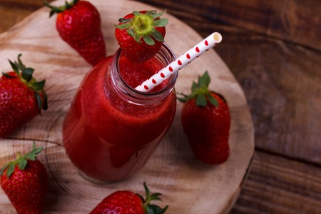 Fresh strawberry smoothie on rustic wooden background, closeup, selective focusの写真素材