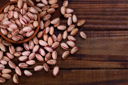 Pistachio nuts in wooden bowl, closeup,selective focusの写真素材