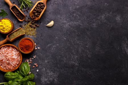 Spices and herbs over black stone background. Top view with free space for menu or recipes.の写真素材