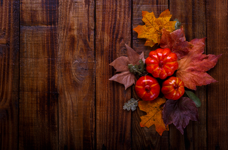 Autumn decorations on old wooden background, pumpkins and dried leaves with copy spaceの写真素材
