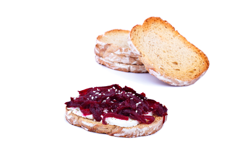 Healthy toast with feta cheese beetroot and sesame seeds on a plate, over white backgroundの写真素材