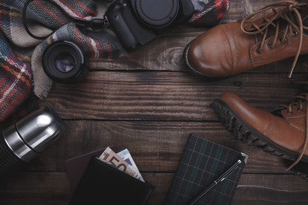 Traveler's photographer's accessories camera lense boots thermos purse with money plaid and notepad on old barn wood backgroundの写真素材