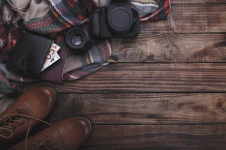 Traveler's photographer's accessories camera lense boots thermos purse with money plaid and notepad on old barn wood backgroundの写真素材
