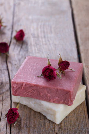 Natural hand made soap with dry pink roses on vintage wooden background spa settingの写真素材