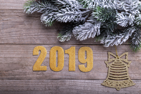 New year background 2019 pine tree branch covered with snow and decorations on old rustic surface
