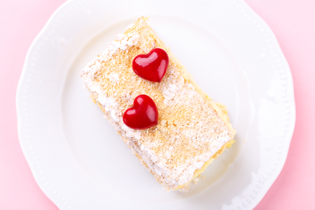 French Mille feuille cake with vanilla cream decorated with hearts on a pink background for Valentine's dayの写真素材