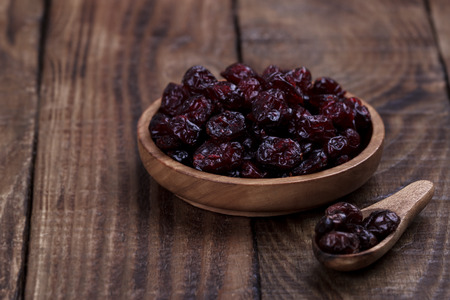 Organic raw dry cranberries in a bowl on dark wooden backgroundの写真素材