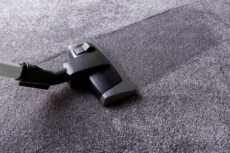 Closeup of vacuum cleaner over grey carpetの写真素材