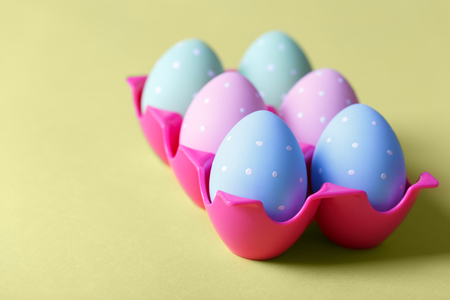Painted colorful Easter chicken eggs in yellow background copy spaceの写真素材