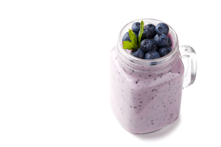 Blueberry smoothie in a glass jar garnished with berries, isolated over whiteの写真素材