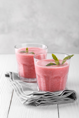 Strawberry smoothie or mikshake in a glass, healthy refreshing drink, verticalの写真素材