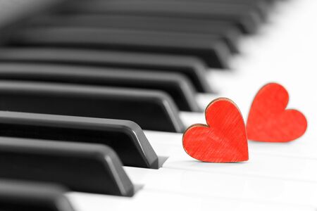 Romantic concept, piano and red wooden hearts, close upの写真素材
