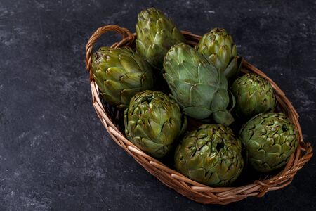 Ripe organic artichokes on black slate stone background, copy spaceの写真素材